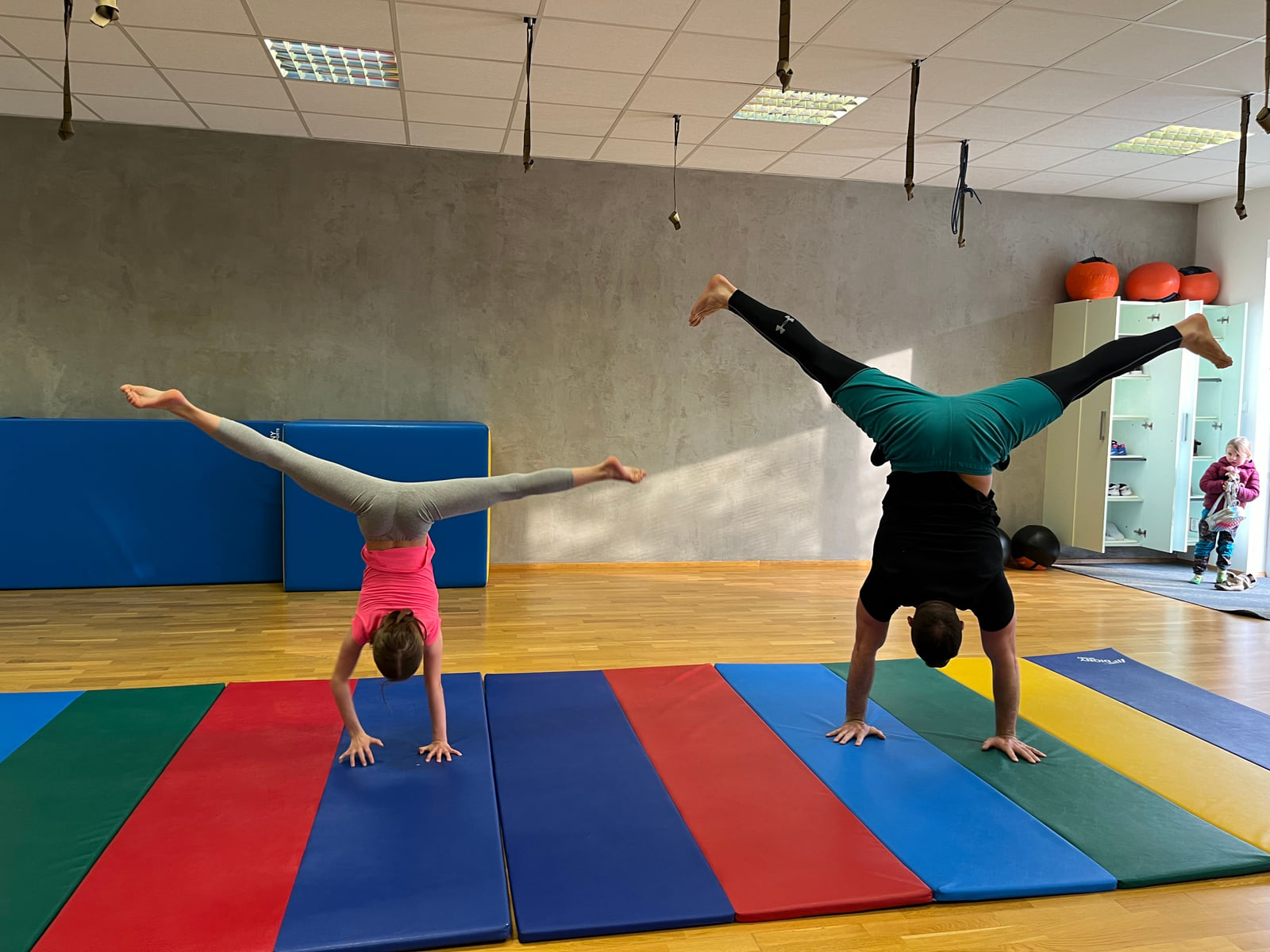 Dvě děti ve stojce na žíněnkách na kurzu MOVEKIDS